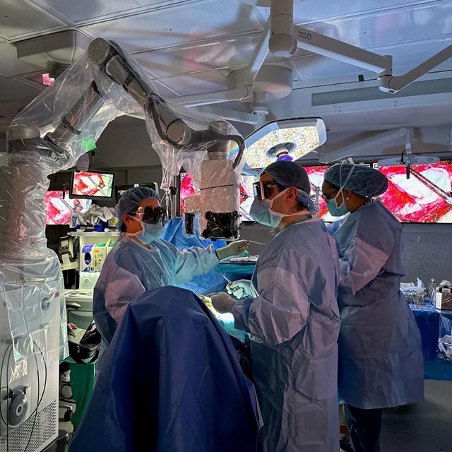 Neurosurgeon Judy Huang (right) uses the robotic exoscope to assist her in performing surgery.